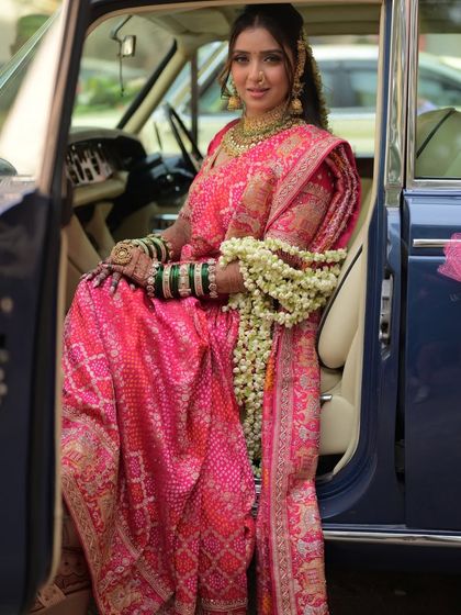 The bride looks like royalty in her vintage ride. The makeup is timeless, ensuring these photos will be cherished for a lifetime.