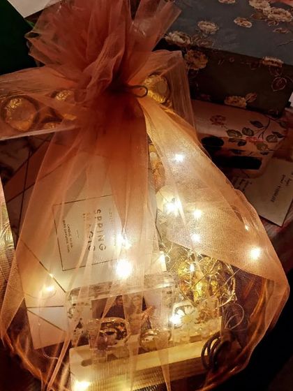 A beautifully wrapped custom gift hamper for Valentine's Day, complete with fairy lights for a magical touch.