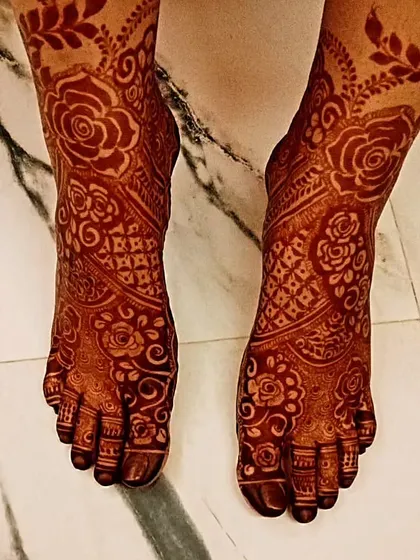 The beautiful, dark stain on this bride's feet, featuring a lovely floral and lattice pattern.