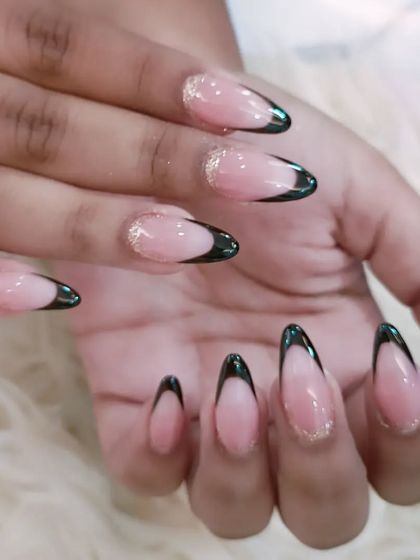 A full view of the elegant black French tips with a fine gold glitter accent line.