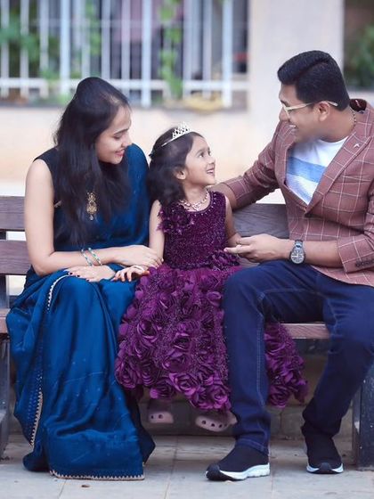 A relaxed family portrait on a park bench. Outdoor settings are perfect for capturing natural interactions and genuine smiles.