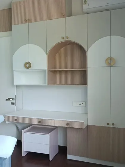 I designed this integrated unit for a child's bedroom, combining a study desk, bookshelves, and full-height wardrobes. The arched cabinet doors and fluted panel details add a soft, modern touch while maximizing storage.