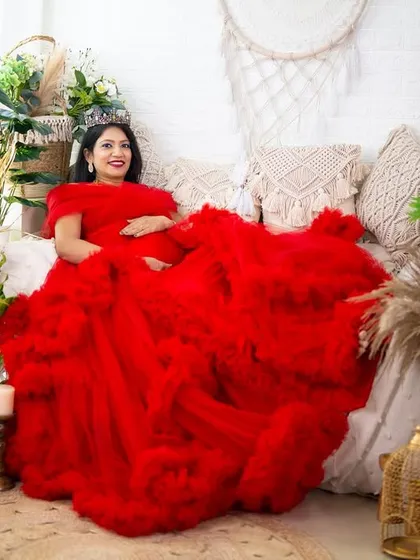Creating a fairytale scene with a vibrant red gown in our fully decorated boho studio. This wide shot captures the entire setup, showing the level of detail we put into every session.
