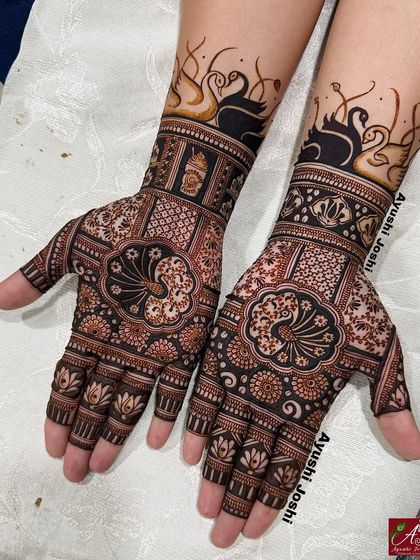 An elegant engagement design with bold, modern swans at the wrist, complemented by traditional peacock and floral patterns on the palms.