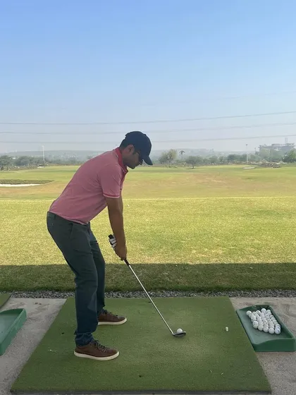 A player lines up their shot on one of our high-quality hitting mats, with the open range stretching out before them.