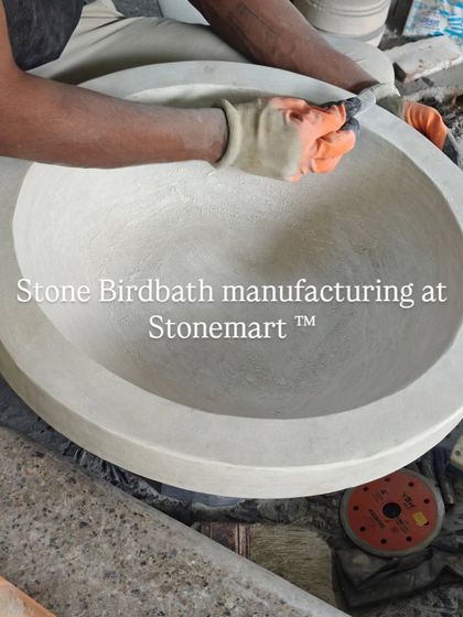 The manufacturing of a stone birdbath bowl. The inside is being smoothed and shaped by hand.