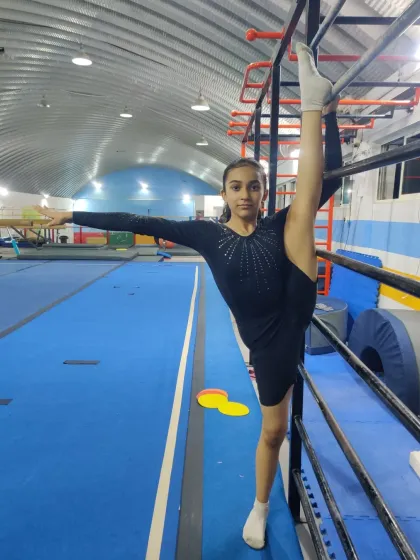 This gymnast shows off her amazing flexibility with a standing split. It's a testament to her hard work and the effectiveness of our flexibility programs.