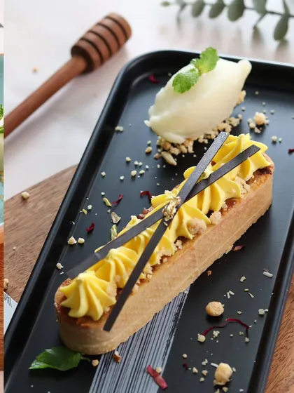This dessert shot focuses on elegance and detail. The sharp lines of the pastry, the piped cream, and the delicate chocolate garnishes are all captured with precision to showcase the chef's artistry.