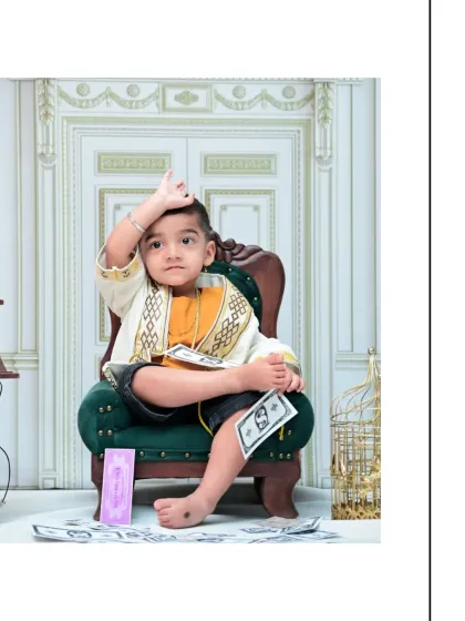 This little guy is having fun playing with prop money in his vintage-themed shoot. I love capturing these candid moments that show off a child's playful spirit.