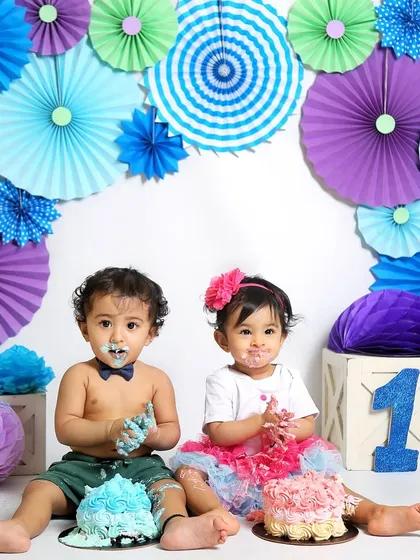 A colorful twin cake smash session. Each baby has their own cake, and their expressions are priceless as they dig in for the first time.