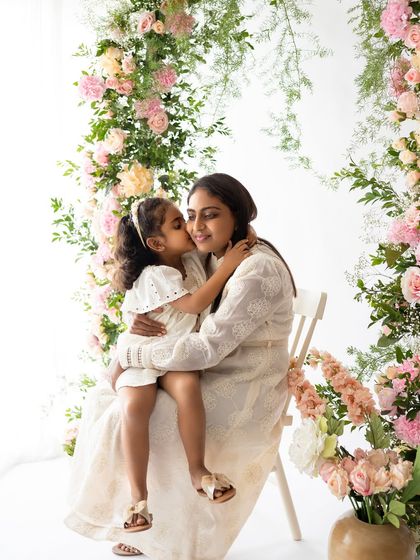 A gentle kiss on the cheek. These are the tender moments that mothers will cherish forever. The soft colors of the flowers complement their white dresses perfectly.