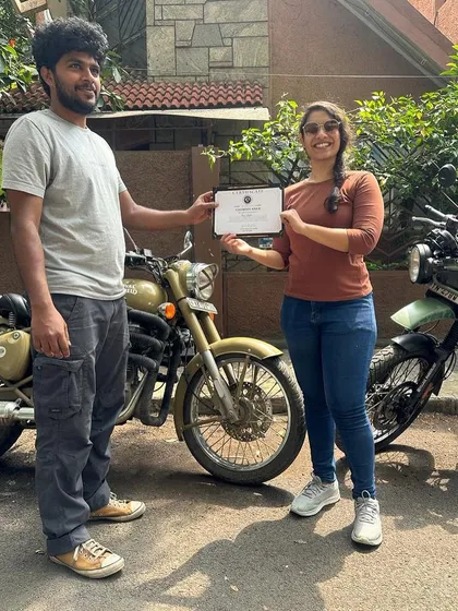 A student proudly accepts her certificate. This moment marks the beginning of her journey as an independent rider.