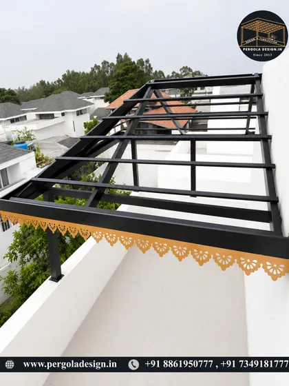 The framework for a modern black pergola with a decorative gold trim, shown during the installation phase on a terrace.