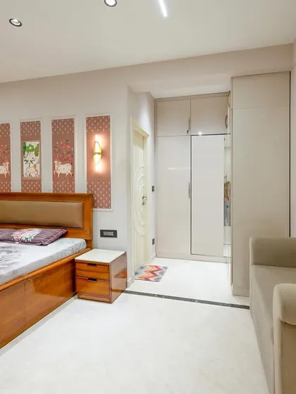 This contemporary bedroom features a neutral palette and clean lines, creating a calm and inviting atmosphere. The custom art panels above the bed add a personal touch, while the integrated lighting enhances the sense of quiet luxury.