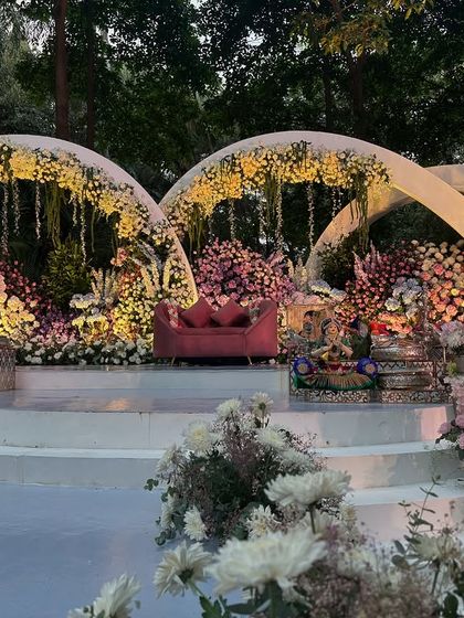A full view of the enchanting outdoor stage with floral arches.