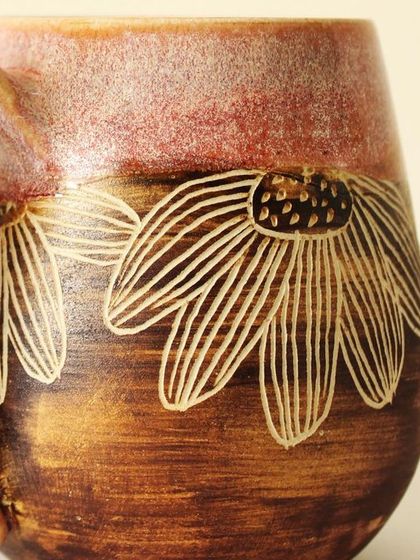 A close-up of the hand-carved floral details on my Pink Sienna mug. I use a technique called sgraffito to etch the design, revealing the natural clay color underneath the rich glaze.