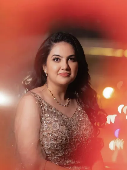 An artistic shot with a beautiful light flare. The bride's makeup remains the focus, with a flawless finish that looks stunning in creative photos.