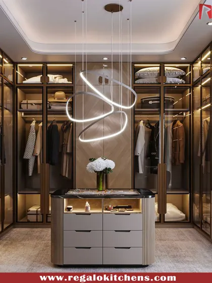 This walk-in closet is defined by its modern aesthetic, featuring a unique swirling light fixture over a functional central island. Glass doors and warm interior lighting keep the space feeling open and inviting.