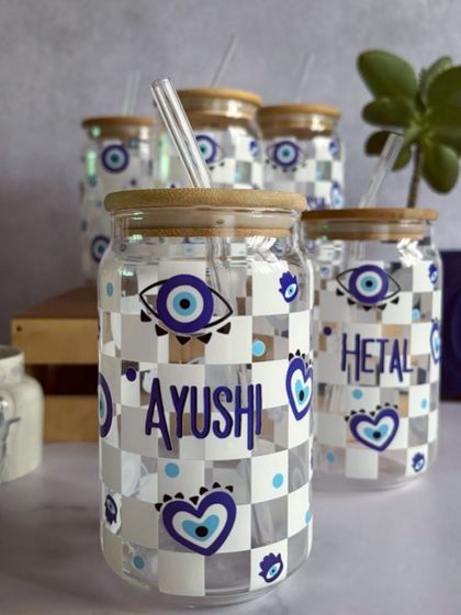Ward off bad vibes with every sip from our evil eye themed glass tumblers. These can-shaped glasses come with a bamboo lid and straw, and we can add your name for a personal touch.