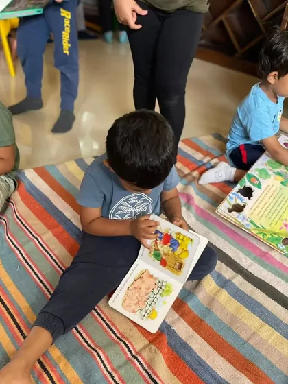 A duplicate shot of a boy engrossed in his book on the floor.