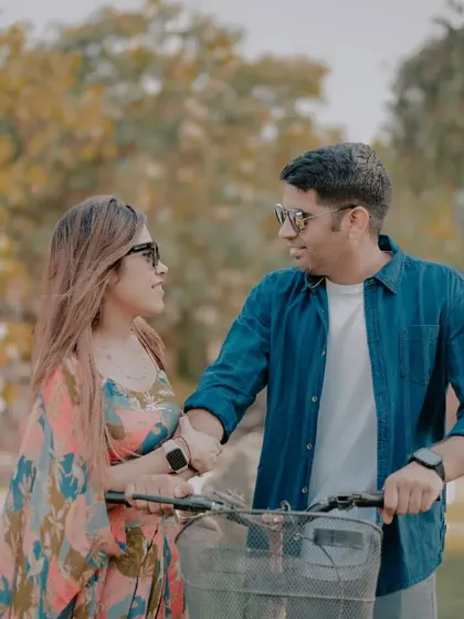 A casual and romantic shot of a couple walking with a bicycle on our lawn. The natural lighting and relaxed interaction make for a beautiful candid portrait.