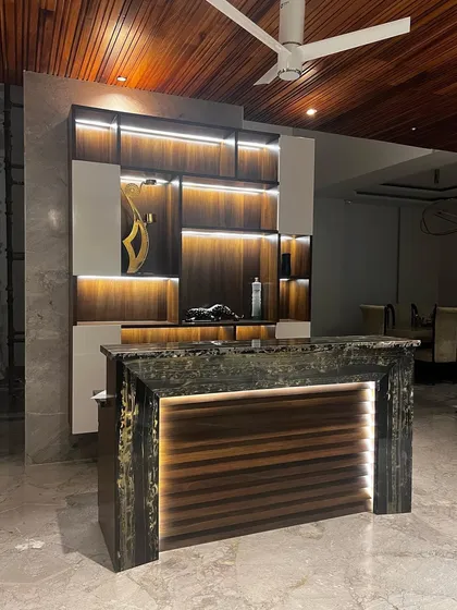 I designed this home bar to be a standout feature for entertaining. The unit combines rich wood textures with sleek white panels and integrated LED strip lighting to highlight the shelving. The bar counter itself is a statement piece, crafted from a unique, textured stone and underlit to create a dramatic and luxurious effect.