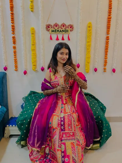 The lovely Shrutika at her mehendi ceremony. She looks radiant and happy, and her colorful outfit perfectly complements the rich tones of her henna.