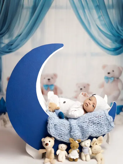 Another angle of our moon prop, this time with the baby awake and looking around. We work at the baby's pace, capturing both sleepy and alert moments.