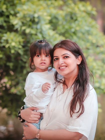 A mother holds her daughter in a beautiful outdoor setting. We use natural light to create soft, flattering family portraits.
