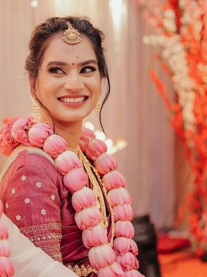 A beautiful, happy South Indian bride. Her makeup is minimal and fresh, letting her joyful smile and the traditional gold jewellery be the focus.