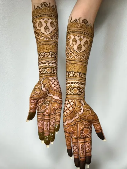 Jhumka motifs and floral bands make this bridal design unique. The patterns are meticulously applied for a flawless finish.