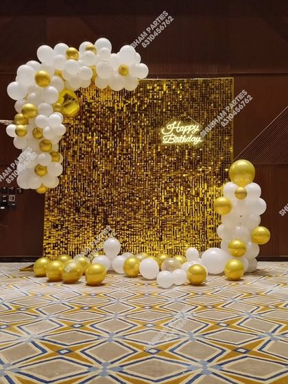 A gold sequin panel decoration with a white and gold balloon garland, creating an elegant photo corner.