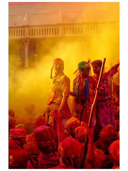 A man stands amidst a cloud of yellow powder, a central figure in the vibrant chaos of Holi. This image captures the feeling of being at the heart of the celebration.