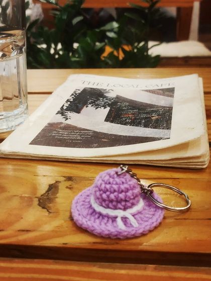 A tiny purple crochet hat keychain, reminding us to appreciate the small, beautiful details in life. It's a charming accessory for your keys or bag.