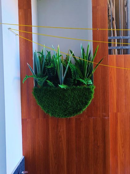 We also create custom wall planters with different types of foliage. This version features a mix of artificial snake plants and ferns for a purely green, textural look.
