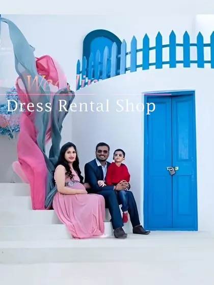 A lovely family maternity photo showcasing our dual-tone pink and grey flying tail gown. The fabric's movement adds a whimsical touch to this portrait, set against a clean, white-and-blue backdrop.
