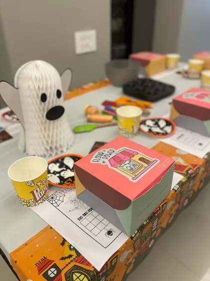 My Halloween workshop setup, complete with spooky decorations and individual baking kits for each child. I bring all the tools and ingredients needed for a fun session.