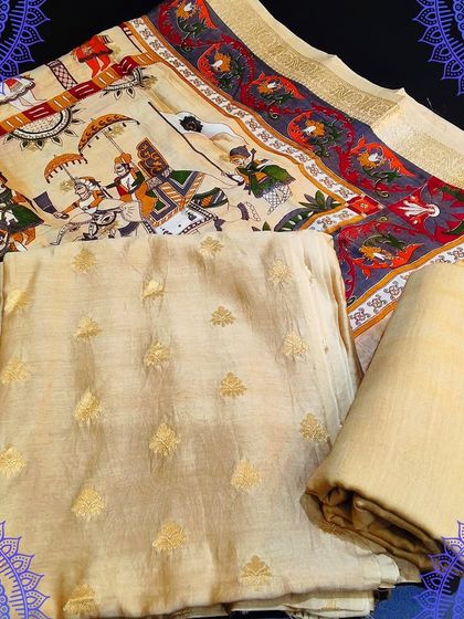A unique unstitched dress material with a digital print dupatta depicting a royal procession. The top fabric is a subtle cream color with small zari butis, perfect for a statement look.
