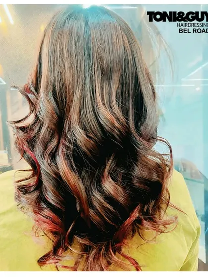 We added warmth and dimension to this client's hair with a mix of red and copper highlights. The soft curls at the end help the different tones catch the light beautifully, creating a rich and dynamic look.