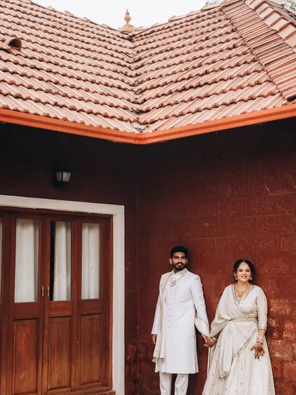 A portrait of Sushma and Rohan holding hands against a striking red wall. The contrast in colors makes this a bold and memorable shot.