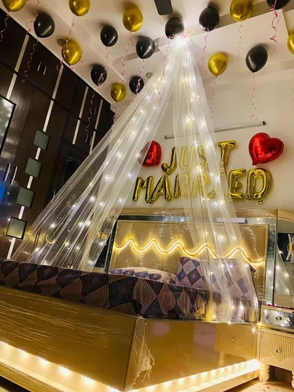 For a more modern first night decoration, I used a black and gold theme with a large, illuminated canopy and "Just Married" foil balloons.