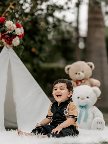 A big, happy laugh is the best thing to capture. This little boy's joyful expression during his outdoor birthday shoot with a teepee and teddy bears is a perfect example of a genuine, happy moment.