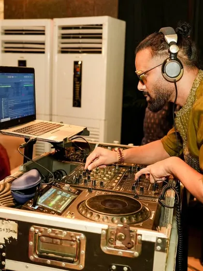 In the zone during a Dandiya night, mixing traditional Garba tracks with Bollywood beats. You can see my complete DJ setup with my laptop and mixer, ready for a long night of music.