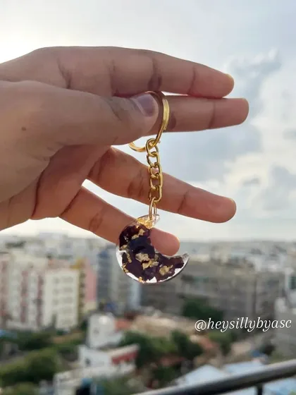 You can carry your memories with you. I created this moon-shaped keychain by preserving a client's special rose petals with flecks of gold. It’s a small, personal way to keep a treasured flower close.