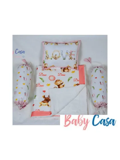 The full "Monkey Love" bedding set. It includes a personalized quilt, a central "Love" pillow, and two bolster pillows, all in a soft color palette with cute monkey and feather prints.