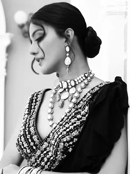 A classic black and white portrait that adds a timeless feel to this modern cocktail look. The monochrome effect emphasizes the shapes and textures of the polki jewellery and the embellished saree.