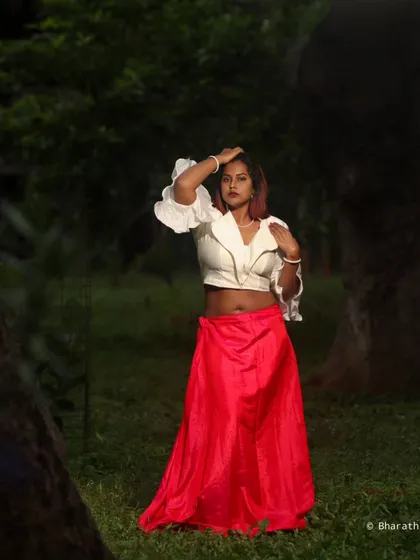 A full-length shot of the fusion look, showing the contrast between the structured top and the flowing skirt. The dark, moody background makes the colors pop.