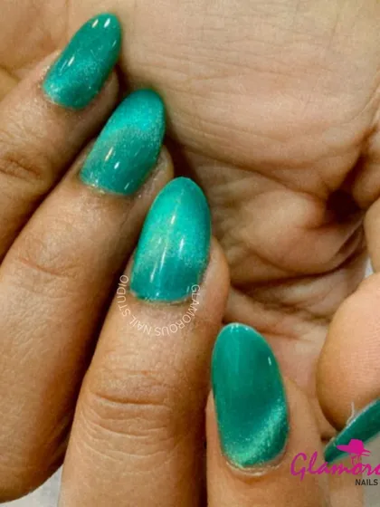A stunning cat-eye effect in a beautiful shade of teal. The magnetic polish creates a diagonal line of light that moves with your hand, giving the nails a unique, gem-like quality.