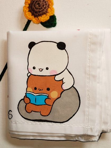 Reading together is a love language. This hand-painted handkerchief captures that quiet, cozy moment perfectly.
