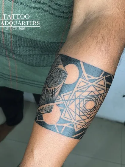 Armbands are a popular choice, and we create them with custom geometric and mandala patterns. This design shows how we use negative space and linework to create a unique band.